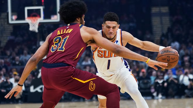 Phoenix Suns' Devin Booker (1) drives on Cleveland Cavaliers' Jarrett Allen (31) during the first half of an NBA basketball game Wednesday, Nov. 24, 2021, in Cleveland. (AP Photo/Tony Dejak)
